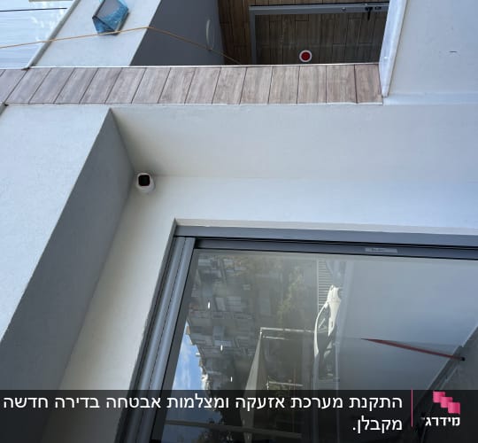 מצלמת אבטחה מותקנת על קיר חיצוני לבן